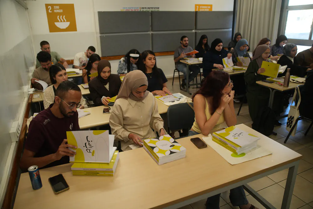 طلاب في قاعة الدرس يتصفّحون كتب سراج الموزّعة على طاولاتهم